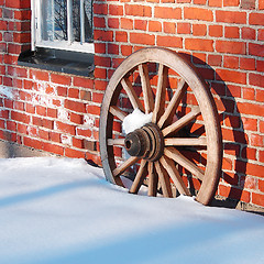 Image showing Wooden wheel and brick wall