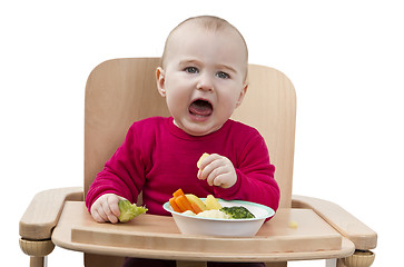 Image showing young child eating in high chair