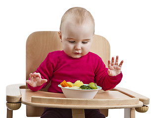 Image showing young child eating in high chair