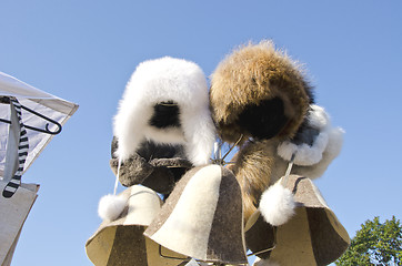 Image showing Winter furred hats caps sold at market fair sky 