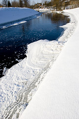 Image showing River in winter and passing ice pieces and rural houses. 