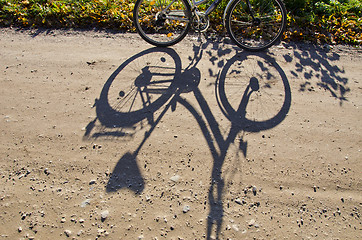 Image showing Standing bicycle shadow on gravel road. 