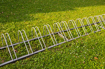 Image showing Healthy travel. Parking for bicycles on grass.