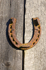 Image showing Rusty horseshoe nailed on old wall. Luck sign. 