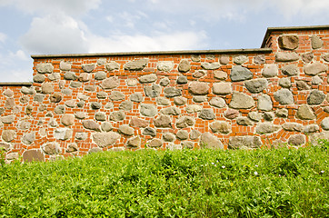 Image showing Restored ancient wall made of red brick and stones. 