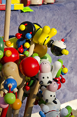 Image showing Wooden toys on a stick sold in outdoor fair. 