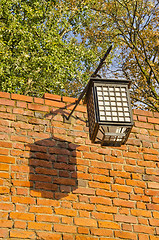 Image showing Ancient illuminator mounted on red brick wall. Oldtown details. 