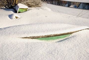 Image showing Snow covered boats fragments protruding from snow. 