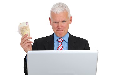 Image showing Businessman with Bills and Laptop on Sofa