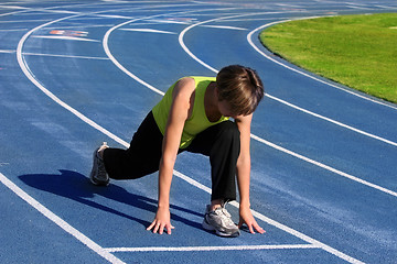 Image showing Woman exercising on a blue racetrack