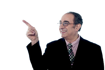 Image showing Senior smiling director pointing away