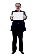 Image showing Senior business professional holding blank billboard