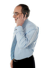 Image showing Side view of a senior manager attending phone call