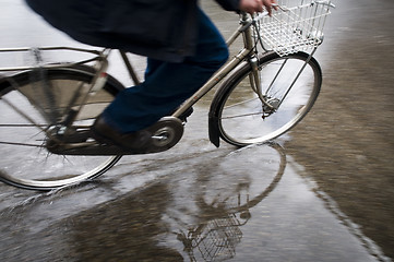 Image showing Man on bicycle in puddle