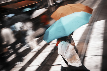 Image showing Two women under umbrella crossing