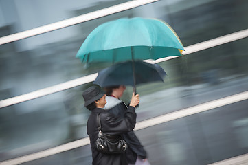 Image showing Two women under umbrella in rain