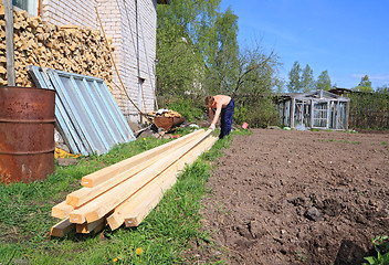 Image showing carpenter raises wooden board