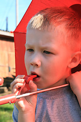 Image showing small boy under red umbrella