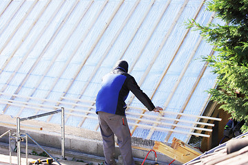 Image showing roofer working on a new roof in wood