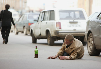 Image showing Alcoholic lies on the road