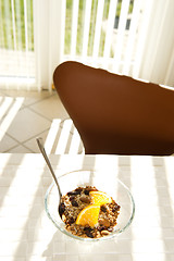 Image showing Healthy muesli with orange in the morning sun