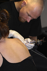 Image showing a man tattooing