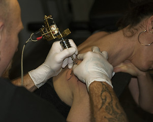 Image showing a man tattooing a woman