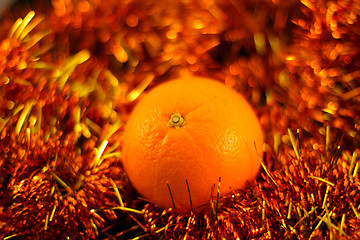 Image showing orange close up on a background of twinkling garlands