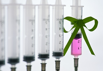 Image showing syringes pink liquid with ribbon of grass