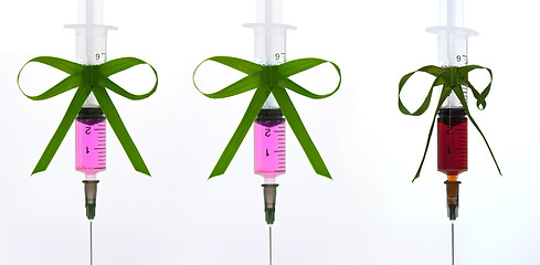 Image showing syringes pink liquid with ribbons of grass