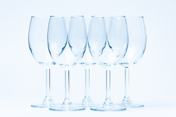 Image showing Empty wine glasses stand symmetrically on white