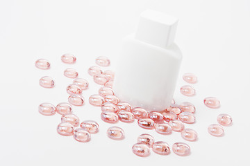 Image showing white container for cosmetics on pink glass stones