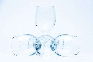 Image showing Wine glasses stand and lie symmetrically on white