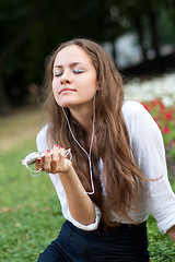 Image showing young woman listens to music in ear-phones