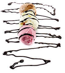 Image showing Tricolor scoops on a row with melted chocolate lines