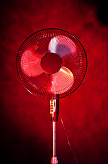 Image showing office fan on dark red background