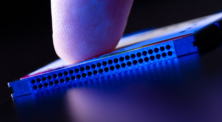 Image showing finger on flash card in blue light closeup