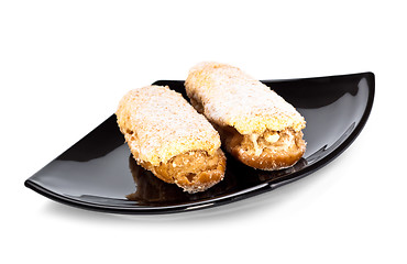 Image showing two eclairs on black dish