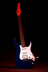 Image showing electric guitar in ray of red light