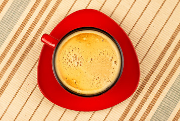 Image showing red coffee cup on striped tablecloth