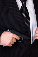 Image showing man drawing his gun from jacket pocket