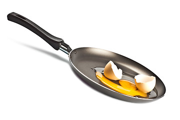 Image showing raw egg and shell on black pan