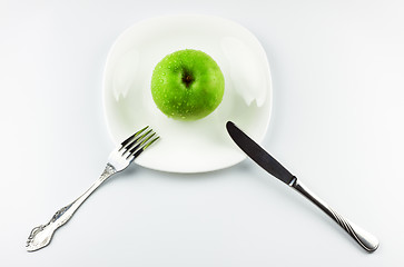 Image showing fork, knife, green apple on white dish