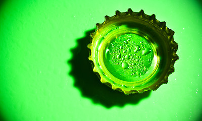 Image showing beer cap with water drops on green