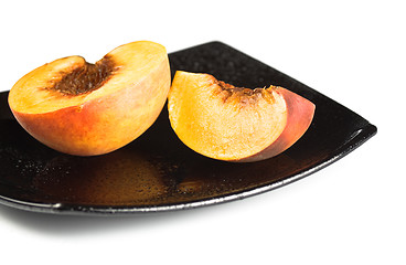 Image showing red peaches slices on black dish
