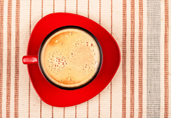 Image showing red coffee cup on striped tablecloth