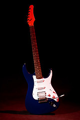 Image showing electric guitar in ray of red light