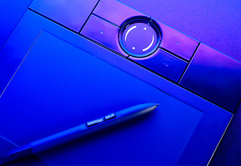 Image showing drawing tablet with pen in blue light