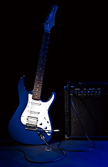 Image showing electric guitar and combo amplifier in rays of blue light