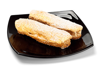 Image showing two eclairs on black dish